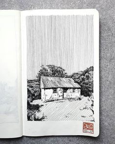 an open book with a drawing of a house in the middle and trees behind it