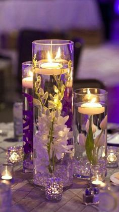 candles and flowers in glass vases on a table