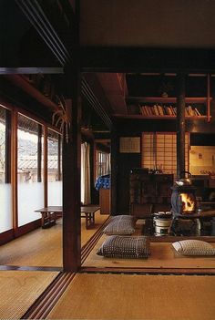 a living room filled with furniture and a fire place in the middle of it's floor