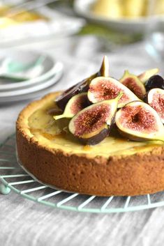 a cheesecake topped with sliced figs on a wire rack