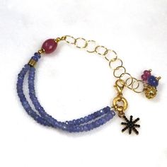 Glittering, vibrantly hued genuine polished natural periwinkle hued tanzanite, one of the rarest and most prized of all gemstones, sparkles on this strand in a beautiful bright striking splash of color! A plump faceted pink sapphire accents the side of the wrist. 14k gold fill chain and colorful drop embellishments add a little chic bling. l Blue Bracelet With Gemstone Accents As Gift, Blue Bracelets With Gemstone Accents As A Gift, Blue Bracelets With Gemstone Accents For Gift, Blue Faceted Amethyst Jewelry, Faceted Blue Amethyst Jewelry, Spiritual Blue Amethyst Bracelets, Blue Tanzanite Gemstone Bracelets, Blue Tanzanite Bracelet Jewelry, Blue Amethyst Beaded Bracelets As Gift