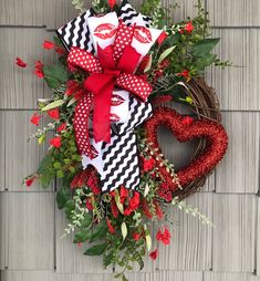 a valentine's day wreath hanging on the side of a house