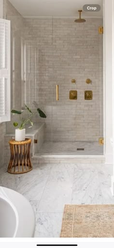 a bathroom with white walls and marble flooring is featured in an article about how to use gold hardware