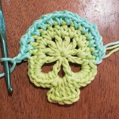 a crocheted skull is sitting on a table next to a pair of scissors