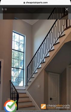 an empty staircase leading up to a window in a home with white walls and black railings