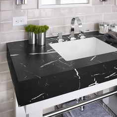 a black and white bathroom sink with marble counter top