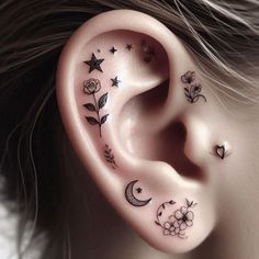 the ear is decorated with flowers, stars and crescents as well as moon and star tattoos