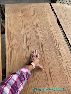 a person reaching for something on top of a wooden table