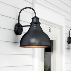 an outdoor wall light on the side of a house with white sidings and windows