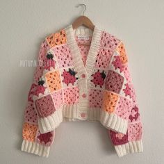 a crocheted sweater hanging on a wall