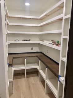 an empty room with white shelves and wood flooring