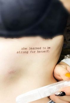 a woman with a small tattoo on her stomach saying she learned to be strong for herself