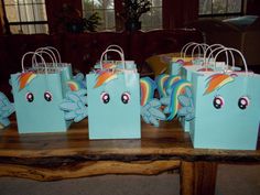 some little bags that are sitting on a table with rainbows painted on the bags