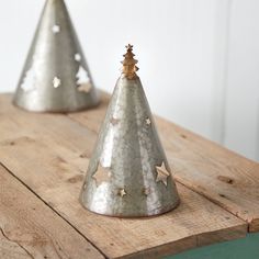 two small metal christmas trees on top of a wooden table