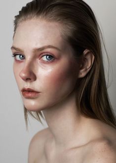 a woman with freckled hair and blue eyes is posing for a photo shoot