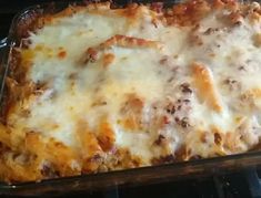 a casserole dish with cheese and meat in it sitting on the stove top