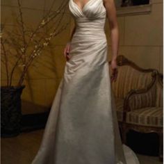 a woman in a white wedding dress posing for a photo with her hand on her hip