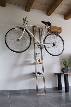 a bike mounted to the side of a wall next to a shelf with shoes on it