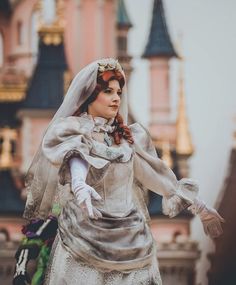 a doll dressed in an old fashion wedding dress and veil with her hands out to the side