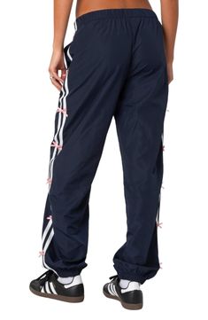 Get active in these sporty track pants designed with bow-trimmed stripes racing down the sides. Elastic waist Side-seam pockets 100% polyester Machine wash, dry flat Imported Navy Sporty Pants With Three Stripes, Sporty Navy Pants With Three Stripes, Track Shirt, Get Active, Pants Design, Nordstrom Store, Track Pants, Elastic Waist, Track