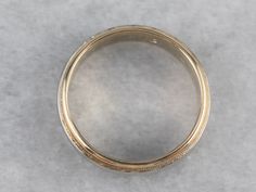 Polished two-tone gold provides a beautiful weight upon the hand in this vintage wedding band. The minimalist style and milgrain edged creates a sophisticated style upon the hand! Metal: 14K White and Yellow Gold Width of Band: 4.4 mm Height off Finger: 1.6 mm Ring Size: 6 Marks: "14K" Stamped on the inside band White Gold Wedding Band With Milgrain Detail, Milgrain Round Band For Wedding And Anniversary, Milgrain Round Band For Anniversary, Milgrain Round Jewelry For Marriage, Round Milgrain Bands For Anniversary, Anniversary Milgrain Round Band Ring, Anniversary Yellow Gold Rings With Milgrain Detail, Anniversary Yellow Gold Rings With Milgrain, Classic Gold Wedding Ring With Milgrain Detail