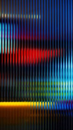 an abstract image of multicolored lines on a wall with the reflection of a television