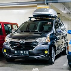 two cars parked next to each other in a parking garage with luggage on the roof