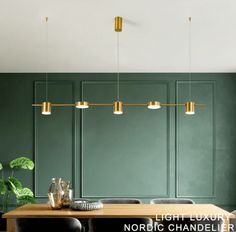 a dining room with green walls and wooden table surrounded by black chairs, gold pendant lights and potted plants