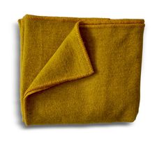 a yellow blanket folded on top of a white surface