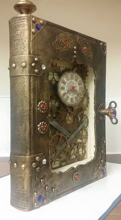 a clock made out of an old book with gears and jewels on the front cover