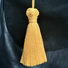 a yellow tassel hanging from a black leather bag