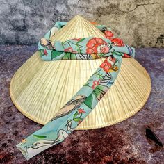 Discover the beauty and authenticity of Vietnamese cone hats, also known as Non La! Straight from the villages of the picturesque Mekong Delta come these original cone hats, handmade by talented women who sew beautiful cloths from scraps of fabric to complete the hat. The Vietnamese cone hat, Non La, embodies traditional craftsmanship and timeless elegance. Each hat tells a story of Far Eastern culture and artistic craftsmanship. Wear this unique accessory and immerse yourself in the fascinating Conical Hat, Cone Hats, Cone Hat, Eastern Culture, Scraps Of Fabric, Mekong Delta, The Villages, Bamboo Frame, Traditional Crafts