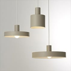 three light fixtures hanging from the ceiling in a room with white walls and flooring