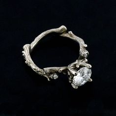 a close up view of a ring made out of tree branches with a diamond in the center