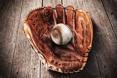 an old baseball mitt with a ball in it sitting on a wooden table top