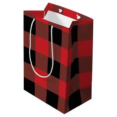 a red and black checkered shopping bag with a white tag hanging from the handle