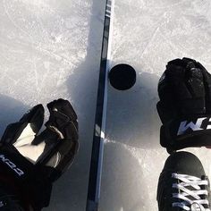 two pairs of hockey gloves sitting on top of an ice rink next to a goalie's mitt