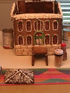 a gingerbread house with icing on the windowsill and other decorations around it