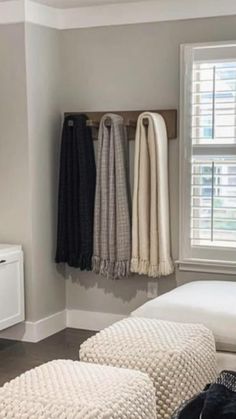 a white bed sitting under a window next to a wall mounted air freshener dispenser