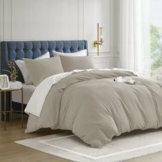 a bed with white sheets and pillows in a room