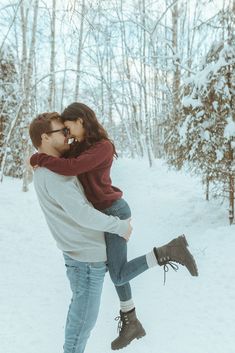 a man and woman are hugging in the snow