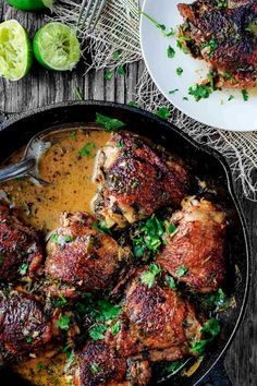 a skillet filled with meat covered in gravy and garnished with cilantro