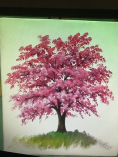 a painting of a pink tree on a green background