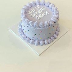 a blue birthday cake with white frosting and sprinkles