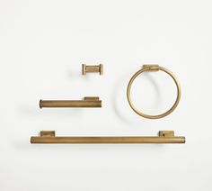 an assortment of brass bathroom accessories on a white background