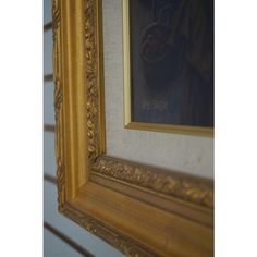 a gold framed painting hanging on the wall