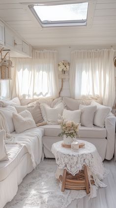 a living room filled with white furniture and windows