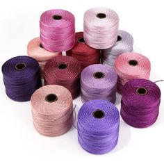 several spools of twine are shown in different colors and sizes on a white background