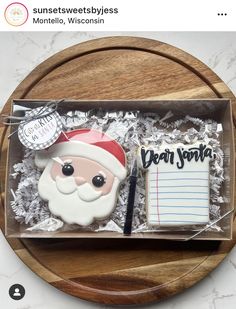 a cookie in the shape of santa claus with a notepad and pen on it