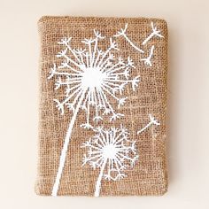 a burlap bag with white dandelions painted on the front and side